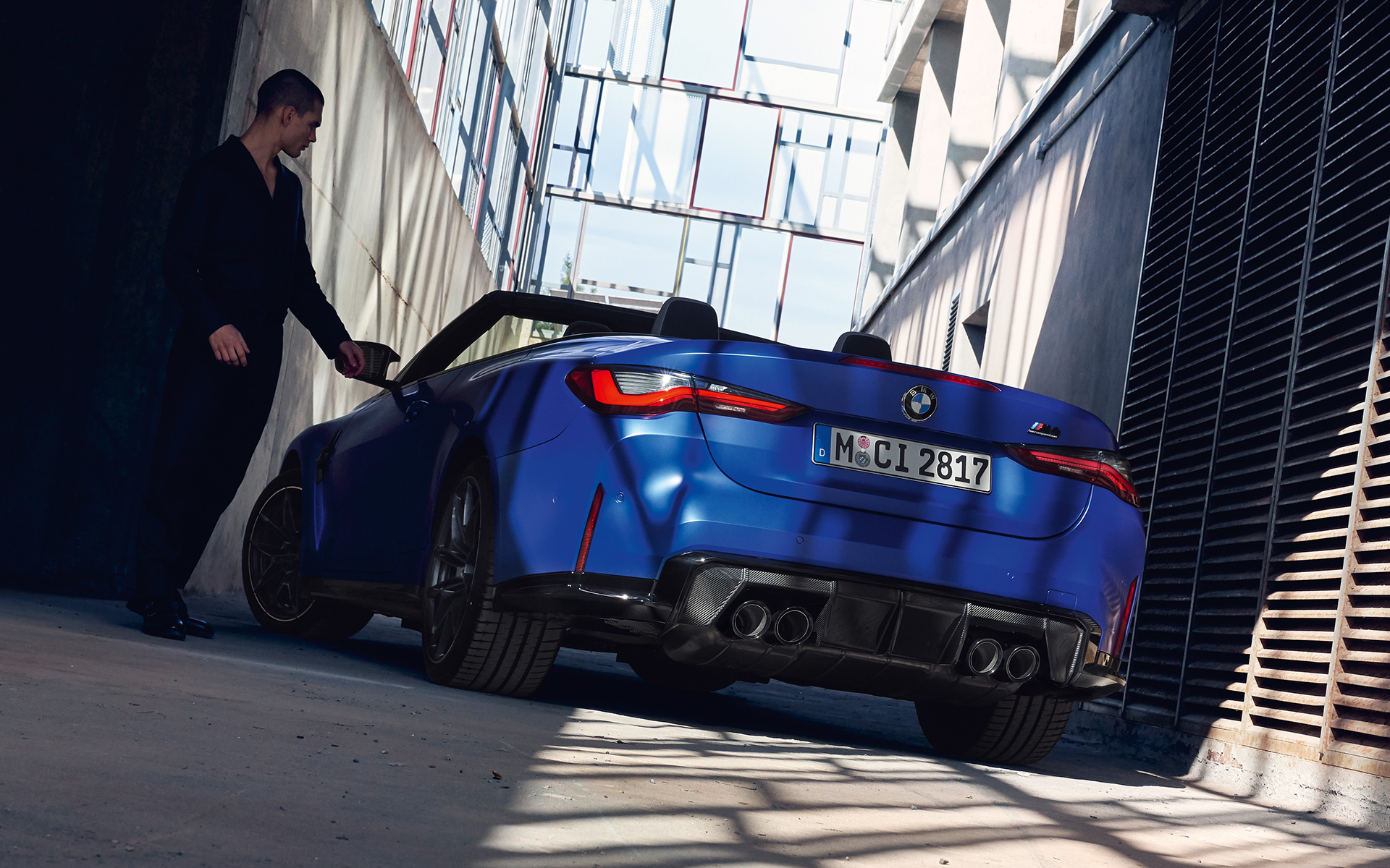  BMW M4 Competition Convertible with M xDrive G83 2021 Frozen Portimao Blue metallic three-quarter rear view with man