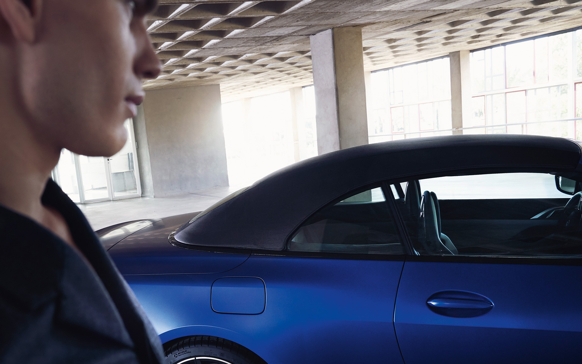 BMW M4 Competition Convertible with M xDrive G83 2021 BMW Individual Frozen Portimao Blue metallic with closed softtop and man in front