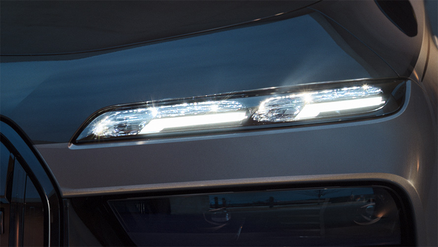 BMW crystal headlights Iconic Glow BMW M760e xDrive Sedan G70 BMW Individual two-tone Black Sapphire metallic paintwork BMW Individual Dravite Grey metallic close-up with lights on