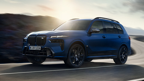 BMW X Series BMW X7 M Automobile G07 MP three-quarter rear view driving on the street