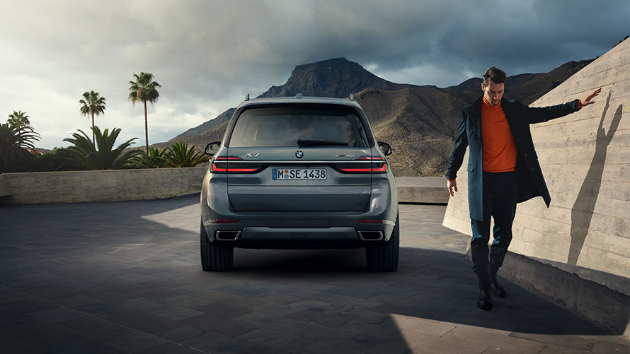 BMW X7 G07 LCI Rear View with model right Sparkling Copper Grey metallic