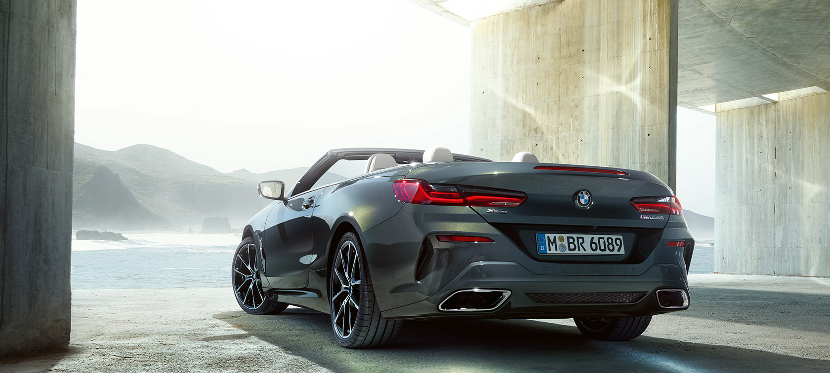 BMW M850i xDrive Dravit Grey metallic, three-quarter view from rear left