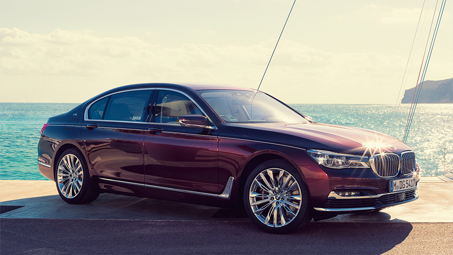 BMW Individual M760Li inspired by Nautor’s Swan G12 2017 three-quarter side view standing at pier in front of sailing yacht in bay